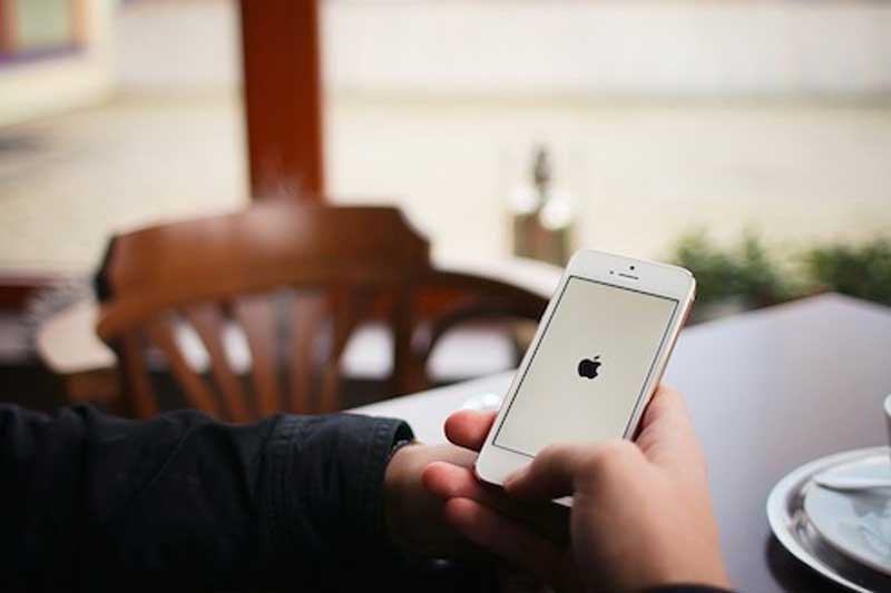 Photo of person checking his iphone.