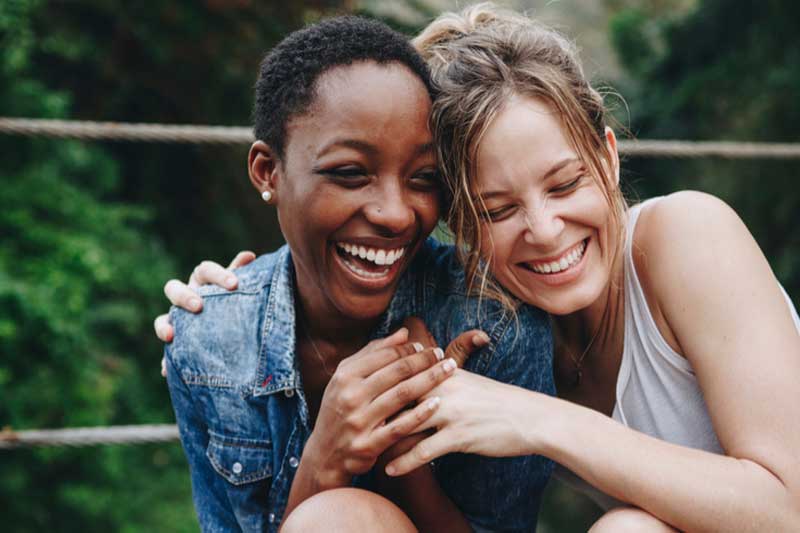 Photo of 2 women laughing together.