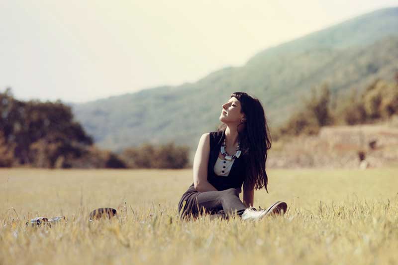 Photo of woman sitting in a field.